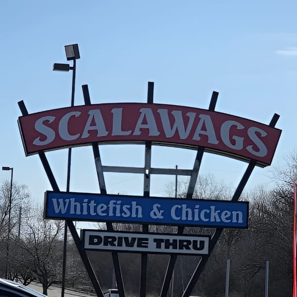 A large outdoor sign for Scalawags restaurant, advertising whitefish, chicken, and a drive-thru.